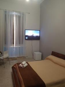 a bedroom with a flat screen tv on the wall at Affittacamere il Labirinto in Bisceglie