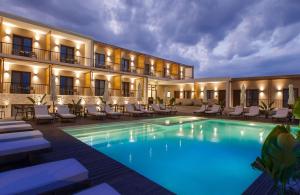 un hotel con una gran piscina y tumbonas en Verano Afytos Hotel en Áfitos