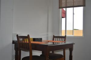 Paramount Residence 5 في Peliyagoda: طاولة طعام مع كرسيين ونافذة