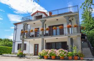 a white house with flowers on the balconies at Apartman Villa Romana in Grožnjan