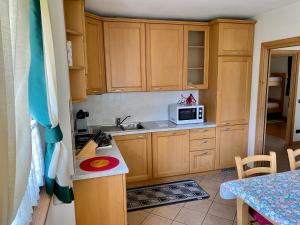 uma cozinha com armários de madeira e um micro-ondas em Chalet Ceppo em Bormio