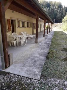 eine Terrasse mit einem Tisch und Stühlen sowie ein Gebäude in der Unterkunft gite à la campagne in Plombières-les-Bains