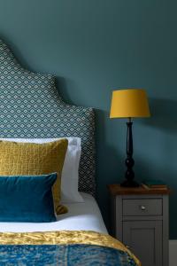 a bedroom with a bed with a lamp on a night stand at The Knowle at St Leonards in St. Leonards