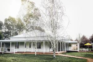 a white house with two trees in the yard at Dal Zotto Homestead & Petite Retreats in Whitfield
