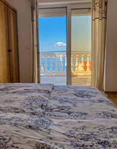 a bedroom with a bed and a view of the ocean at Apartments Villa Klaudia - Adults Only in Crikvenica