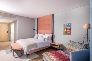 a bedroom with a large bed and a living room at Almond Hotel - Adults only in Neve Ilan