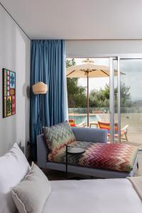 a living room with a couch and a patio at Almond Hotel - Adults only in Neve Ilan