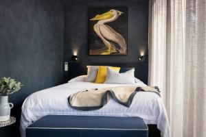 a bedroom with a bed with a bird picture on the wall at Dal Zotto Homestead & Petite Retreats in Whitfield