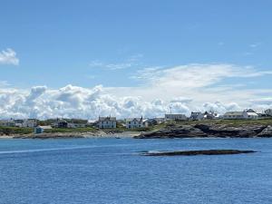 a large body of water with houses in the background at Glasfor by the beach at Trearddur Bay in Trearddur