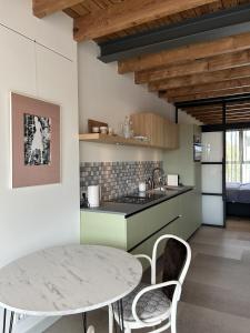 a kitchen with a table and chairs in a room at De Eindhovenaar City Apartments in Eindhoven