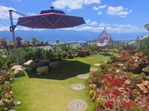 a garden with an umbrella and some flowers at Super Invincible All Seaview Villa in Dali