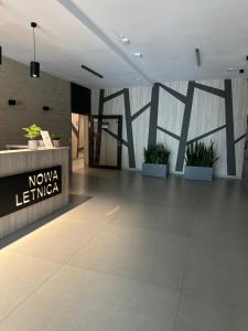 a lobby of a building with potted plants on the wall at Letnica41 by MYPART in your apartment in Gdańsk