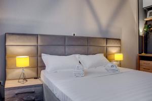 a bedroom with a large white bed with two lamps at CHANTTAL Luxury - UNIVERSITY in Bucharest
