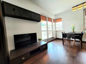 クラクフにあるApartament Dark Chocolate 4 persons Down Townのリビングルーム(テレビ、ダイニングテーブル付)