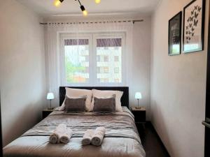 クラクフにあるApartament Dark Chocolate 4 persons Down Townのタオルが敷かれた大きなベッドのある寝室