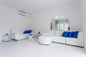 a living room with white furniture and blue pillows at Villa AMICA in Zaton
