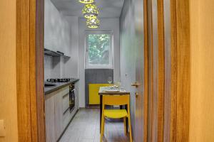 a kitchen with a yellow chair and a table at CHANTTAL Luxury - UNIVERSITY in Bucharest