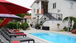 una piscina con 2 sillas y una sombrilla roja en Villa Anne A lovely place in the mountains, en Brest