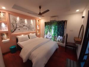 a bedroom with a white bed and a painting on the wall at Honeymoon Houseboat in Alleppey