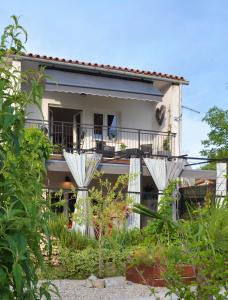 a house with a balcony and two white umbrellas at Villa Anne A lovely place in the mountains in Brest