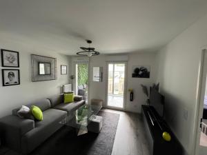 ein Wohnzimmer mit einem Sofa und einem Tisch in der Unterkunft Appartement avec son jardin d’hiver in Poissy