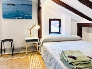 um quarto com uma cama, uma mesa e um espelho em Loft buhardilla en perfecta ubicación em Santander
