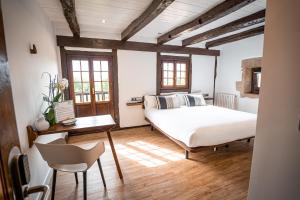 1 dormitorio con 1 cama, mesa y sillas en Casa Rural Arotzenea en Hondarribia