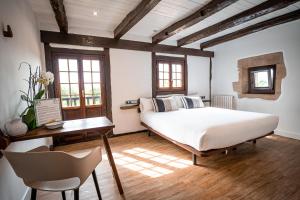 1 dormitorio con 1 cama blanca grande y escritorio en Casa Rural Arotzenea, en Hondarribia