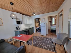 uma sala de estar com um sofá e uma mesa em Ylläksen Metsäpirtti - Ulkoilijan koti em Äkäslompolo