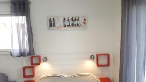 a bed in a room with red frames on the wall at Appartement Alouette France in Pessac