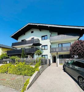 ein weißes Gebäude mit einem davor geparkt in der Unterkunft Ferienhaus Schiemel in Altmünster