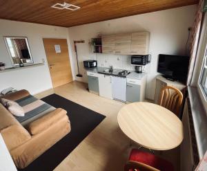 ein kleines Wohnzimmer mit einem Tisch und einer Küche in der Unterkunft Ferienhaus Schiemel in Altmünster