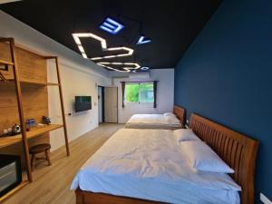 2 camas en un dormitorio con una pared azul en Sky Castle Homestay, en Fengbin