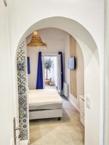 a bedroom with a bed under an archway at Le Santorini - centre ville & terrasse privée in Béthune