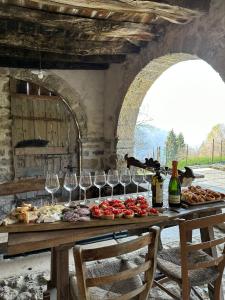 a table with wine glasses and wine bottles at DOSSENA Dimora Storica Al Lac Conte Tomaselli in Madonna della Costa