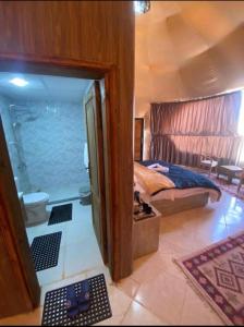 a bedroom with a bed and a bathroom with a shower at camp scylla Wadi Rum in Wadi Rum