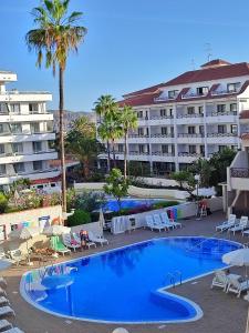 a large hotel with a large swimming pool next to a resort at Favoloso trilocale a Las Americas in Arona
