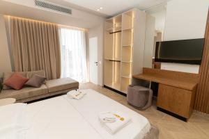 a hotel room with a bed and a flat screen tv at Hotel Memaj in Ksamil