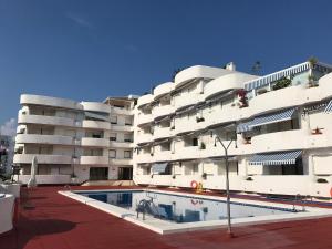a building with a swimming pool in front of it at La Marinada in Cambrils
