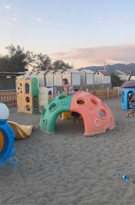 a child is playing on a playground in the sand at 3 MINUTI A PIEDI DAL MARE parking & wifi included FIUMARETTA , in Fiumaretta di Ameglia