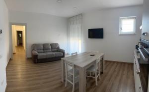 a living room with a table and a couch at LD Ianuzziello Residence - Jonica House in Scanzano