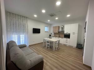 a living room with a couch and a table and a kitchen at LD Ianuzziello Residence - Jonica House in Scanzano