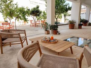 patio z drewnianym stołem i krzesłami oraz stołami i krzesłami w obiekcie Canneddi Boutique Farm w mieście Avetrana