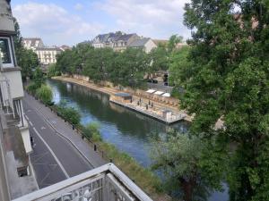 ストラスブールにあるGrand appartement au coeur de Strasbourgの建物のバルコニーから川の景色を望めます。