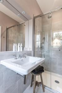 a white bathroom with a sink and a shower at The Knowle at St Leonards in St. Leonards
