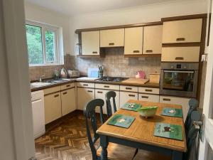 a kitchen with a wooden table and a table and chairs at Ranikhet in Risca