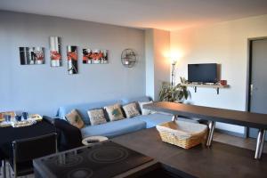 uma sala de estar com um sofá azul e uma televisão em Superbe 3 pièces (2 chambres et salon) + Terrasse 50 m² 6 minutes du centre ville em Bordeaux