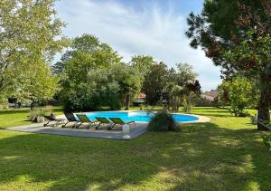 a swimming pool with lounge chairs in a yard at Les Grands Vents in Chervettes