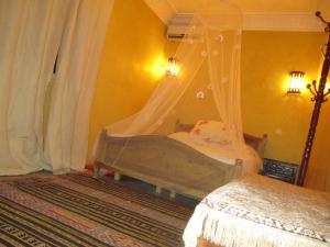 Dormitorio con cama con red en Auberge Cavaliers, en Aït Baha