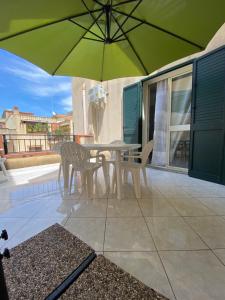 a patio with a table and chairs and an umbrella at [la terrazza del sole] in Menfi